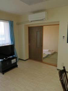 a living room with a television and a mirror at Frontier Sunrise in Kami-furano +33 photos
