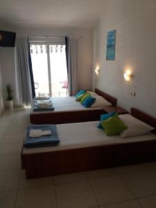 two beds in a room with a large window at Apartments Boris in Omiš