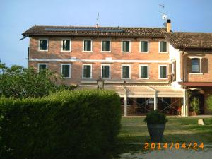 duży budynek z cegły przed dziedzińcem w obiekcie Locanda Antico Fighèr w mieście Musile di Piave