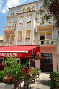 a building with tables and chairs in front of it at Apartment Dora in Crikvenica