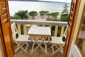 a table and chairs on a balcony overlooking the ocean at Apartment Dora in Crikvenica