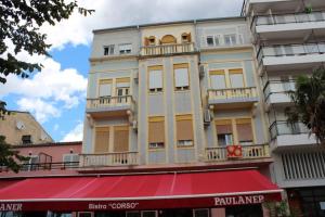 a tall building with a red awning in front of it at Apartment Dora in Crikvenica +2 photos