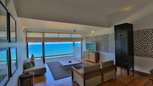a living room with a view of the ocean at Pandanus Beach Resort & Spa in Bentota