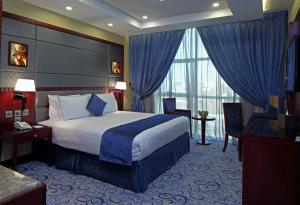 a hotel room with a bed and a large window at Intour Al Khafji Hotel in Khafji