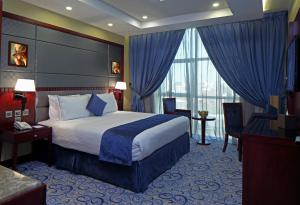 a hotel room with a bed and a large window at Intour Al Khafji Hotel in Al Khafji