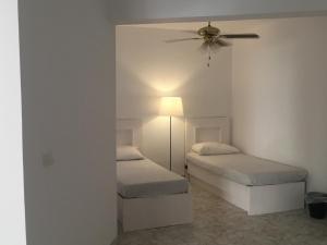 a bedroom with two beds and a ceiling fan at Virginia Beach Standalone Villa in El Alamein