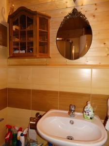 La salle de bains est pourvue d'un lavabo et d'un miroir. dans l'établissement Dworek Telimena, à Smolniki
