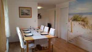 a dining room with a table with white chairs and a tableablish at Ferienwohnung Waterkant in Kappeler Niederstrich