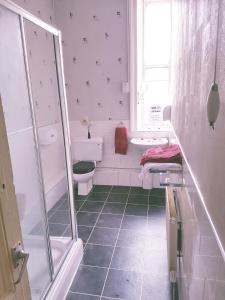 a bathroom with a shower and a toilet and a sink at The King's Head Hotel in Keighley