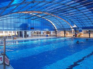 a large indoor swimming pool with people in it at Apartment Ben Gurion in Bat Yam