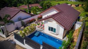 Cette chambre offre une vue sur une maison dotée d'une piscine. dans l'établissement Star 2 BR Private Pool Villa - Chalong, à Chalong