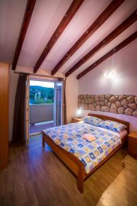 a bedroom with a bed and a large window at Šanić Apartments 518 in Lopar