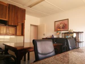 a dining room with a table and black chairs at Monica's Guesthouse in Welkom