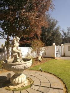 a statue of a girl on a fountain in a yard at Monica's Guesthouse in Welkom