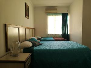 1 dormitorio con 2 camas y ventana en Monica's Guesthouse en Welkom