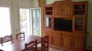 a dining room with a table and a large wooden cabinet at Appartement A Mas Oliva in Roses