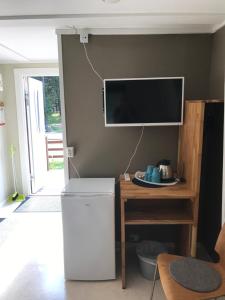 a living room with a refrigerator and a tv on the wall at STF Hostel Visby/Rävhagen in Visby