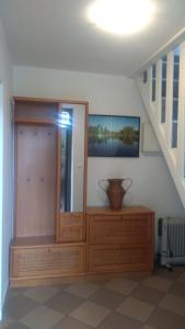Chata Dziadka Ignacego في أوغستوف: غرفة مع خزانة خشبية و مزهرية على طاولة