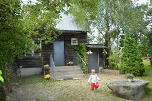 a small child walking in front of a house at Chata Dziadka Ignacego in Augustów