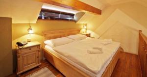 1 dormitorio con 1 cama blanca grande y 2 lámparas en Hotel Horní Dvůr, en Nové Město na Moravě
