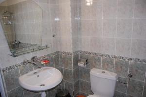 a bathroom with a white toilet and a sink at Guest Rooms Biju in Tryavna +20 photos
