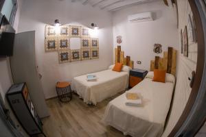 Zimmer mit 2 Betten und einem Spiegel in der Unterkunft Minicasa el Mesoncico in Cehegín