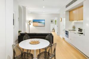 a living room with a table and a couch at Orange Stay Apartments Potts Point in Sydney