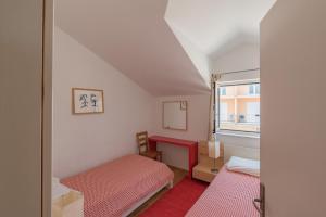 a small room with two beds and a window at Apartments Mazuran in Hvar