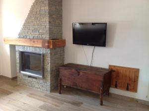 a living room with a fireplace and a flat screen tv at Cianfuran 2 in Bardonecchia