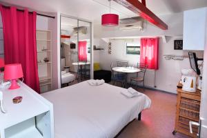 リヨンにあるstudios peniche Lyon centre Vieux Lyon Confluenceのベッド2台と赤いカーテンが備わる客室です。