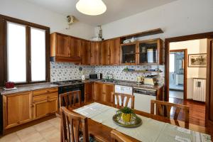 a kitchen with wooden cabinets and a table with a dining room at Liberty Mansion in Venice-Lido