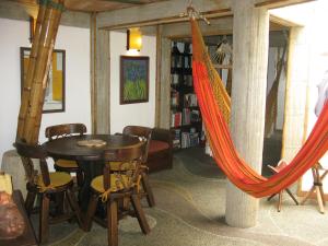 a room with a hammock and a table and chairs at Kasaguadua - RESERVA NATURAL in Salento