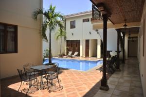 a patio with a table and chairs next to a pool at El Almirante in Granada