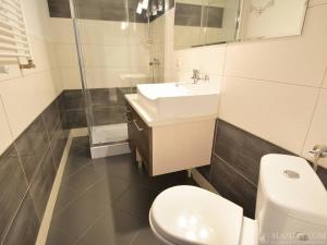 a white bathroom with a sink and a toilet at Pod kogutkiem in Kruklanki