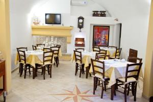 a dining room with tables and chairs and a fireplace at Villa Musica in Sannicola