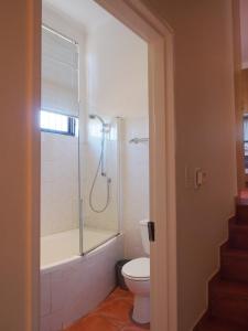 a bathroom with a tub and a toilet and a shower at Swallow's Nest in Somerset West