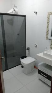 a bathroom with a toilet and a shower and a sink at Casa em São Tomé das Letras in São Thomé das Letras +12 photos