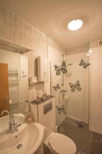 a bathroom with butterflies on the wall and a toilet at Wietheger´s Ferienwohnungen Gästehaus Strycktal II in Willingen