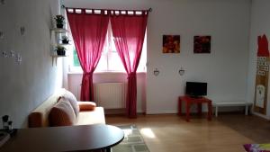 a living room with a couch and a window with red curtains at apartman-Rača in Bratislava