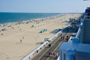 a beach filled with lots of beach chairs and umbrellas at Monte Carlo Boardwalk / Oceanfront Ocean City in Ocean City