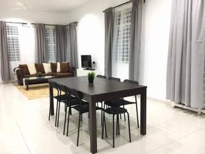 a black table and chairs in a living room at Ceri Merah Homestay in Kuantan