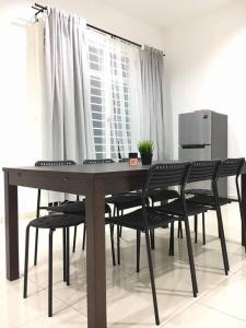 a dining room table with chairs and a refrigerator at Ceri Merah Homestay in Kuantan