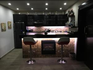 a kitchen with a brick fireplace and two bar stools at Sporting Suite Studio in Alexandria
