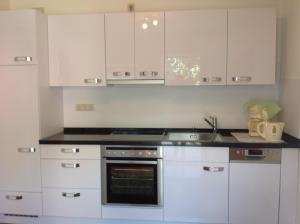 uma cozinha com armários brancos e um forno com placa de fogão em Harztor em Nordhausen