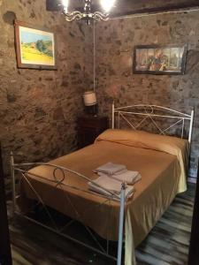 1 dormitorio con cama de metal y lámpara de araña en L'Antico Sogno Guest House en Tramutola