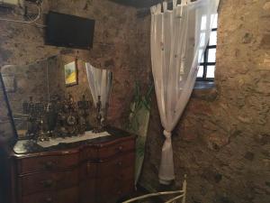 a room with a dresser and a window with a curtain at L'Antico Sogno Guest House in Tramutola