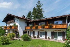 a large house with a balcony and a yard at Pension Wendelstein in Miesbach