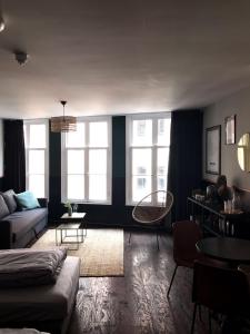 a living room with a couch and two windows at Amsterdam Red Light Bed & Breakfast in Amsterdam