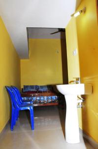 a bathroom with a sink and a blue chair at Akashadeepa Homestay in Madikeri