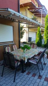 a table and chairs on a patio in front of a house at Dóra Stúdió Apartmanok in Zalakaros